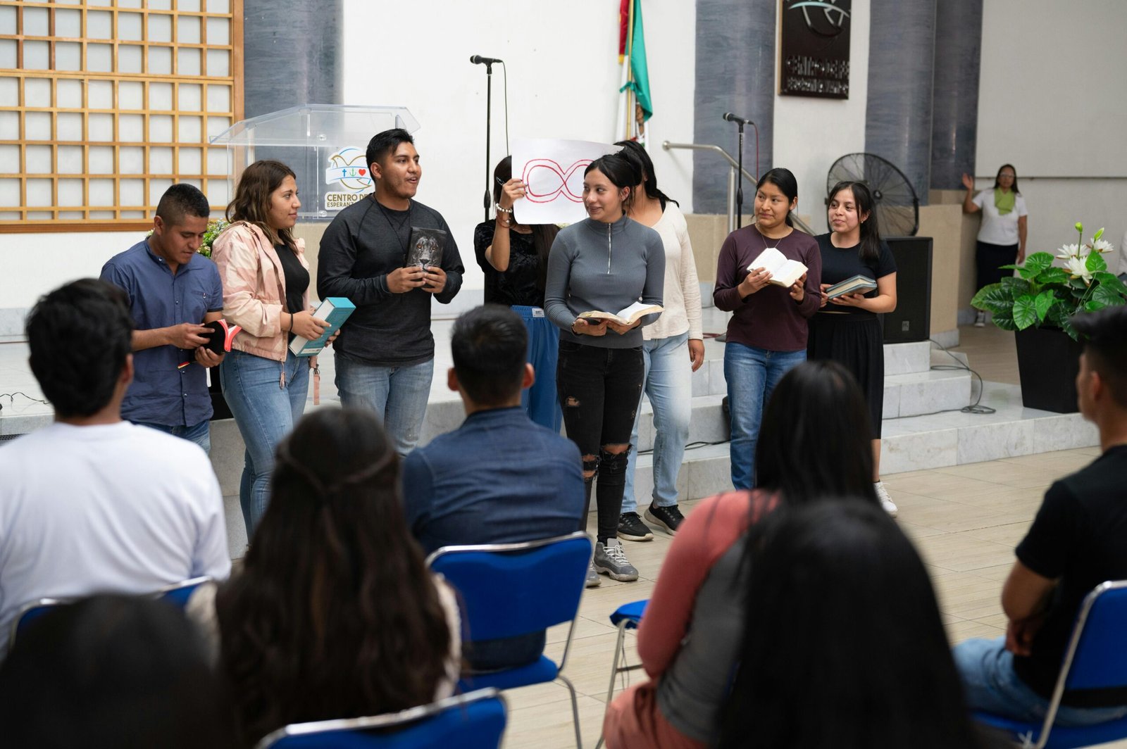 Young adults gather for a religious event at a Mexico City church, reading and participating.