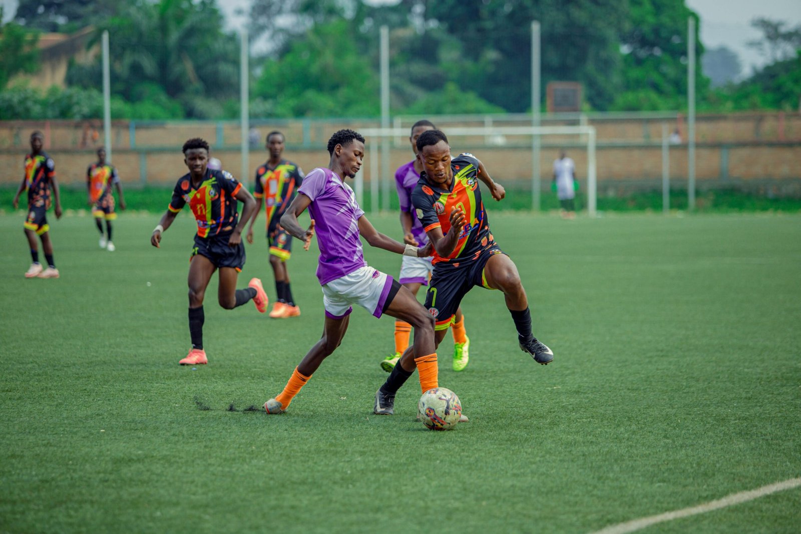Dynamic action shot of young soccer players competing on an outdoor field.