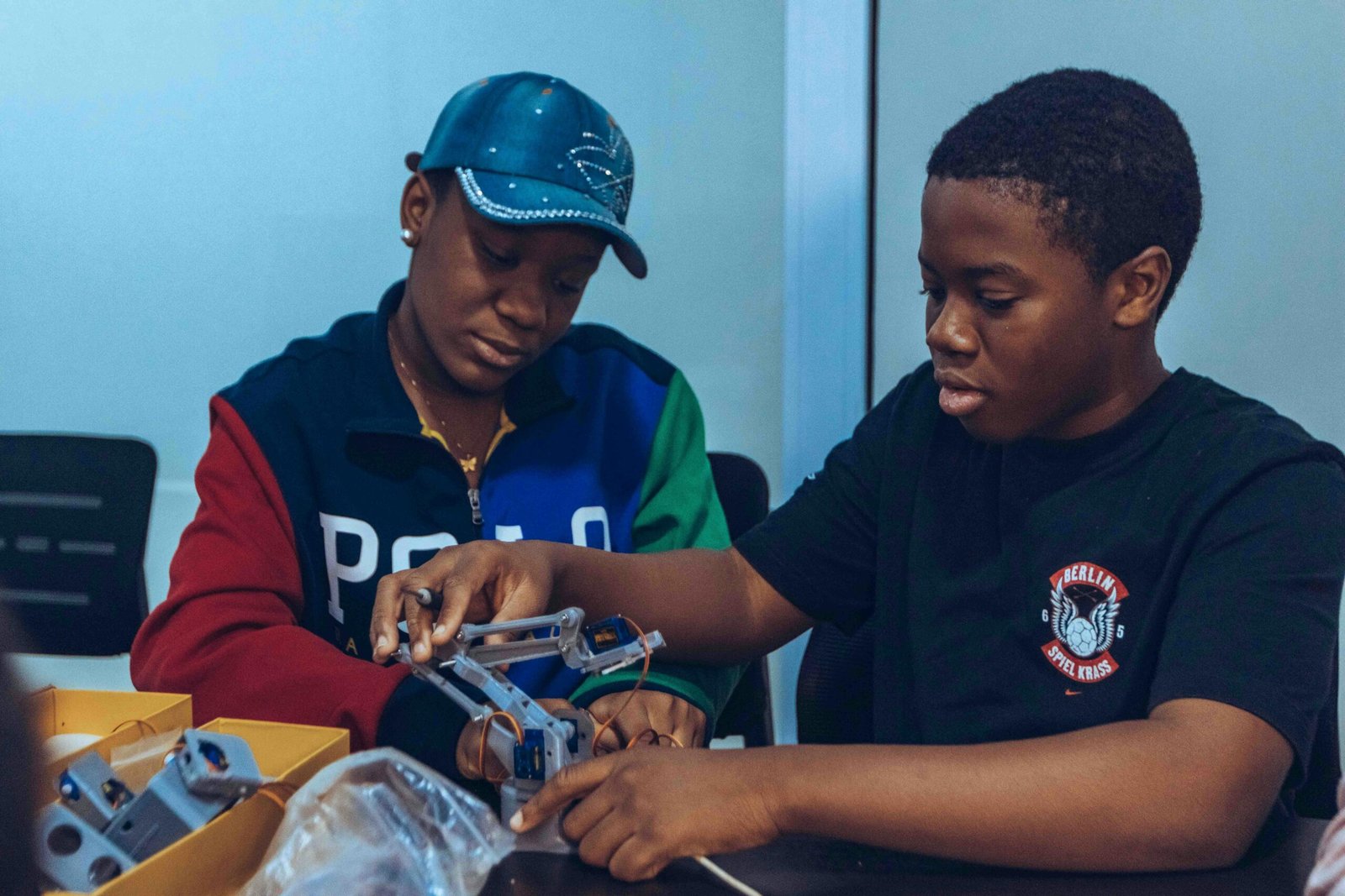 Two students assembling a robot in a hands-on STEM workshop in Accra, Ghana.