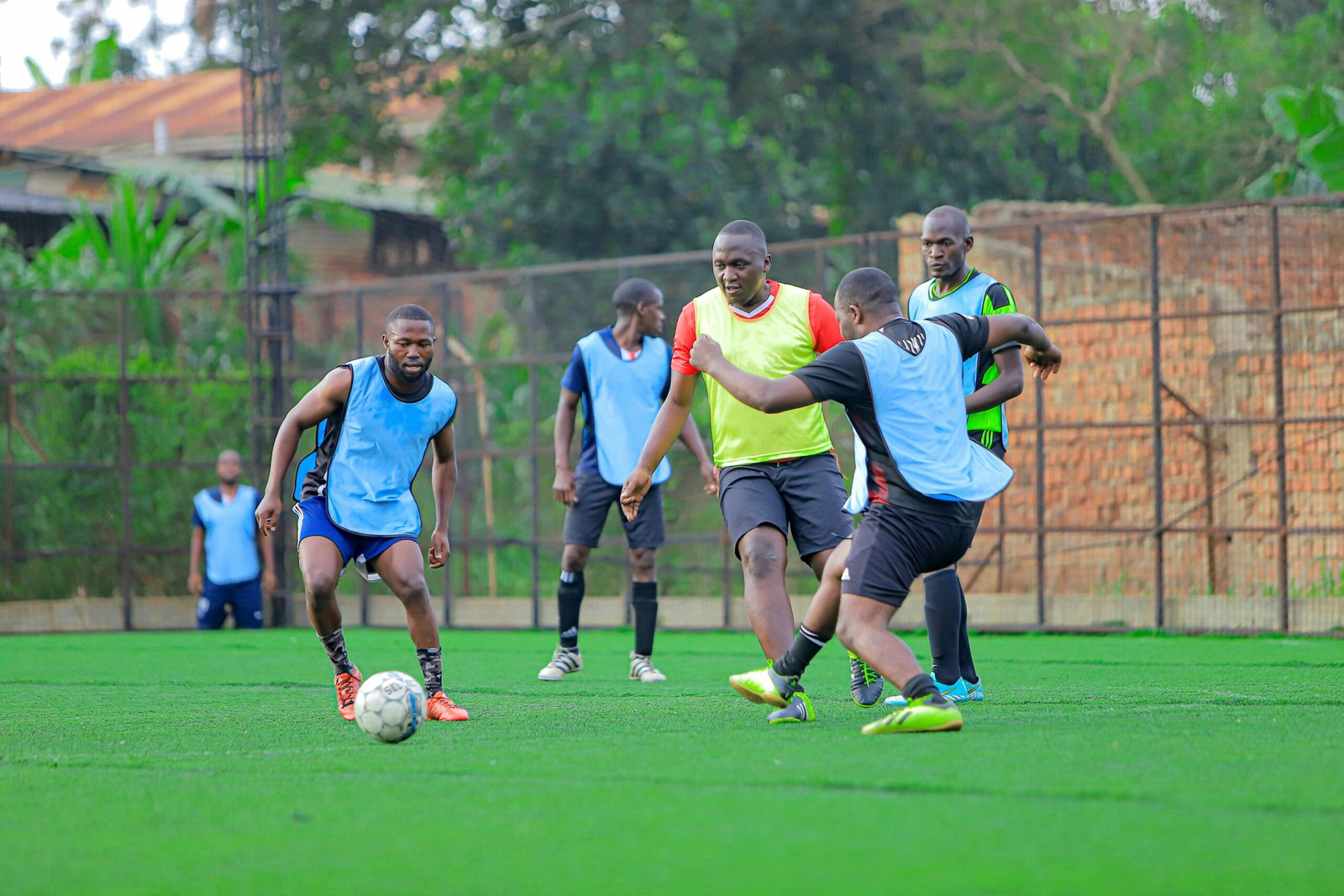 Intense soccer practice with athletes focused on teamwork and skill development on a lush green field.